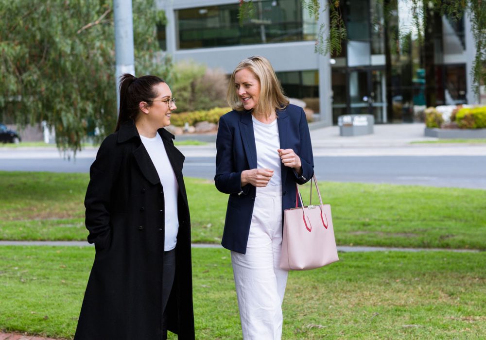 two executives on a walking meeting talking about leader as coach training